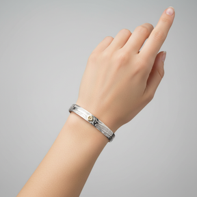 A 7mm width silver cuff bracelet with engraved geometric and floral patterns, featuring a central gold flower accent, shown on a plain white background.