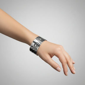 Cuff bracelet with black and white abstract pattern on a white background