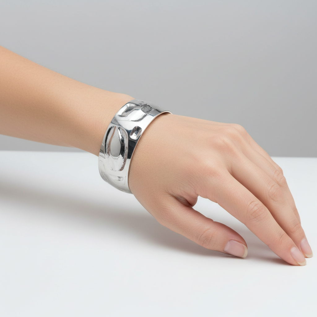 Silver bracelet with intricate designs on a white background