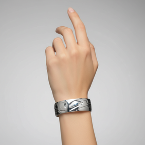 Silver bracelet with a detailed design on a white background